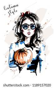 Hand drawn beautiful young woman holding pumpkin. Stylish elegant girl with red bow in her hair. Fashion woman in sunglasses. Sketch.