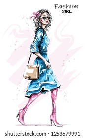 Hand drawn beautiful young woman with bag. Stylish elegant girl in dress. Fashion woman look. Sketch.