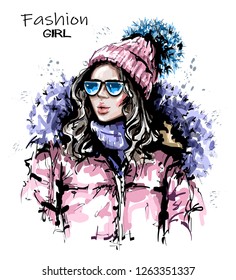Hand drawn beautiful young woman in knit cap. Stylish girl in winter clothes. Fashion woman look. Sketch.