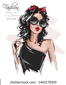 Hand drawn beautiful young woman in sunglasses. Stylish girl with bow on her head. Fashion woman look. Sketch. Vector illustration. - Shutterstock ID 1442178359