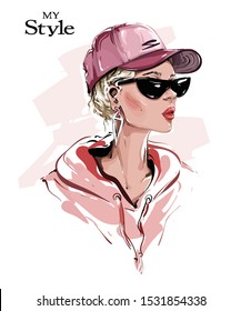 Hand drawn beautiful young woman in cap. Stylish girl in sunglasses. Fashion woman look. Sketch. Vector illustration.