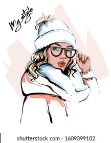 Hand drawn beautiful young woman in winter clothes. Stylish girl. Fashion woman look. Sketch. Vector illustration.