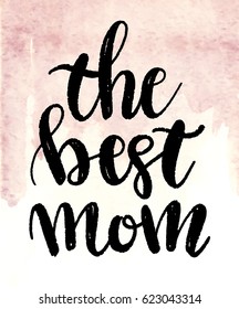 Hand drawn black ink brush lettering "The Best mom" on watercolor painted light pink background. Calligraphy design quote for your print and web products: greeting cards, banners, gift tags, tshirts.