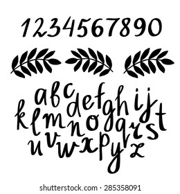 Hand drawn black sketch calligraphical alphabet, font, letters, numbers and leafs, branches isolated on black background 