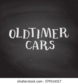 hand drawn chalk lettering "Oldtimer cars" on chalkboard background. Handwritten calligraphy.