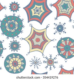 Hand drawn colorful snowflakes doodles arranged in a seamless pattern. Tribal circular patterns. Abstract round design elements.