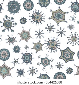 Hand drawn colorful snowflakes doodles arranged in a seamless pattern. Tribal circular patterns. Abstract round design elements.