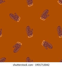 Hand drawn december seamless pattern with brown colored mittens ornament. Dark orange background. Graphic design for wrapping paper and fabric textures. Vector Illustration.