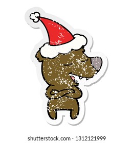 hand drawn distressed sticker cartoon of a bear wearing santa hat
