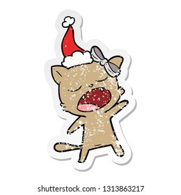 hand drawn distressed sticker cartoon of a singing cat wearing santa hat