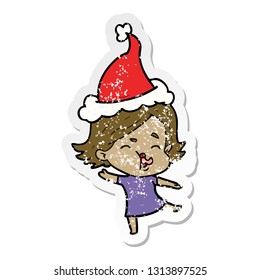 hand drawn distressed sticker cartoon of a girl pulling face wearing santa hat