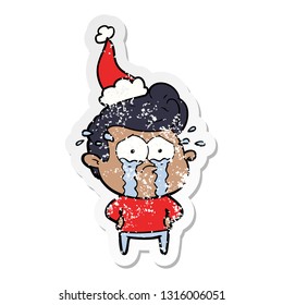 hand drawn distressed sticker cartoon of a crying man wearing santa hat