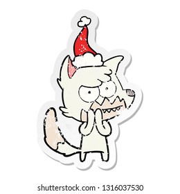 hand drawn distressed sticker cartoon of a grinning fox wearing santa hat