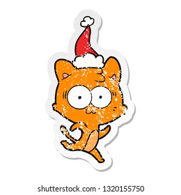 hand drawn distressed sticker cartoon of a surprised cat running wearing santa hat