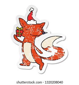 hand drawn distressed sticker cartoon of a happy fox wearing santa hat