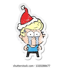 hand drawn distressed sticker cartoon of a crying man wearing santa hat