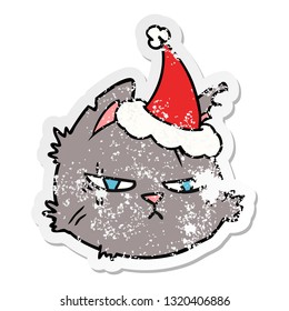 hand drawn distressed sticker cartoon of a tough cat face wearing santa hat