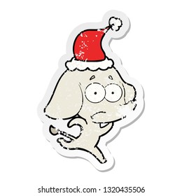 hand drawn distressed sticker cartoon of a unsure elephant running away wearing santa hat