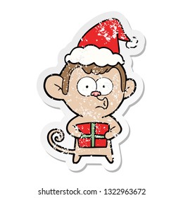 hand drawn distressed sticker cartoon of a christmas monkey wearing santa hat