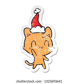 hand drawn distressed sticker cartoon of a happy cat wearing santa hat