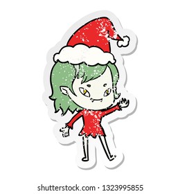 hand drawn distressed sticker cartoon of a friendly vampire girl wearing santa hat