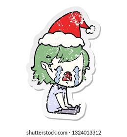 hand drawn distressed sticker cartoon of a crying vampire girl wearing santa hat