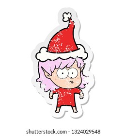 hand drawn distressed sticker cartoon of a elf girl staring wearing santa hat