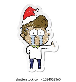 hand drawn distressed sticker cartoon of a crying man wearing santa hat