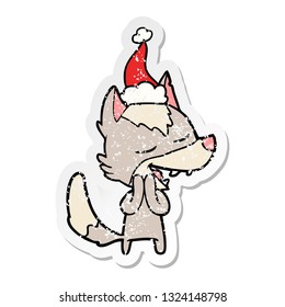hand drawn distressed sticker cartoon of a wolf laughing wearing santa hat