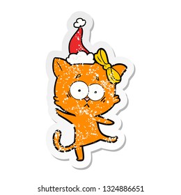 hand drawn distressed sticker cartoon of a cat wearing santa hat