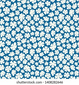 Hand drawn ditsy white flowers on a blue background in a tossed seamless pattern. Pretty floral vector design perfect for fabric and backgrounds.