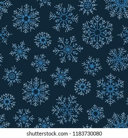 Hand drawn doodle seamless pattern. Blue snowflakes on a dark background. For fabric, textile, wrapping paper, card, invitation, wallpaper, web design.