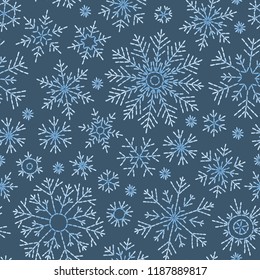 Hand drawn doodle seamless pattern. Blue snowflakes on a dark background. For fabric, textile, wrapping paper, card, invitation, wallpaper, web design.
