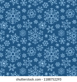 Hand drawn doodle seamless pattern. Blue snowflakes on a dark background. For fabric, textile, wrapping paper, card, invitation, wallpaper, web design.