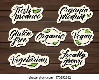 Hand drawn healthy food lettering. Label, badge, logo template on a wooden background. Organic, organic product, gluten free, vegan, locally grown, vegetarian, fresh produce. Eps 10 vector.