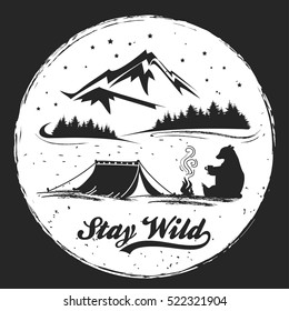 Hand drawn Inspiration and Motivation Typography for t-shirt print. Stay Wild. Travel, adventure, freedom poster with camp, tent, bear and mountains.