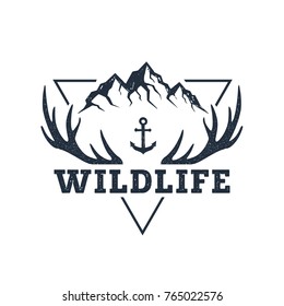 Hand drawn inspirational label with mountains and antlers textured vector illustrations and "Wildlife" lettering.