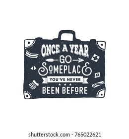 Hand drawn inspirational label with suitcase textured vector illustration and "Once a year go someplace you've never been before" lettering.