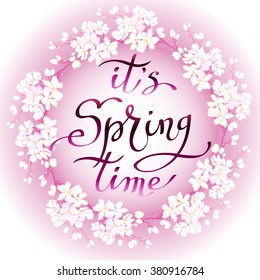 Hand drawn inspirational quote - it is spring time. Pen and ink calligraphy, Brush painted purple red letters on light pink background and blossom cherry branches wreath, vector illustration.