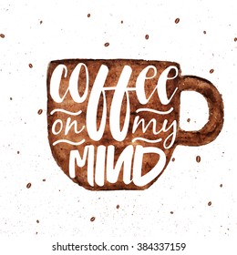 Hand drawn lettering card with watercolor brown coffee cup on white background. Typography design for greeting card, flyer, banner, poster. Coffee on my mind