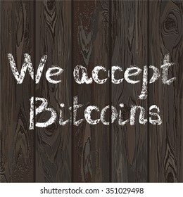 Hand drawn letters we accept bitcoins on wooden texture background