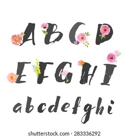 Hand drawn letters written with brush pen. Letters are decorated with watercolor flowers. Capital letters. 