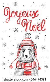 Hand drawn Merry Christmas greeting card. Funny winter bear in knitted hat and scarf and doodle snowflakes. Handwritten lettering "Joyeux Noel", Merry Christmas in French