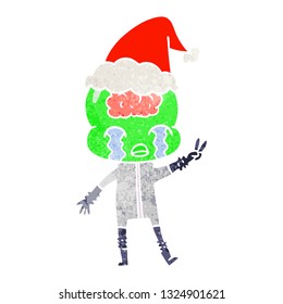 hand drawn retro cartoon of a big brain alien crying and giving peace sign wearing santa hat