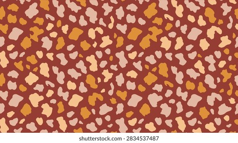 hand drawn seamless pattern featuring abstract animal skin design with warm brown and orange spots for modern textile print design and creative projects