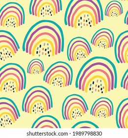 Hand drawn seamless pattern with rainbows Trendy baby texture isolated on yellow background