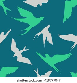 Hand drawn seamless pattern with silhouettes of  flying swallows. Endless green background