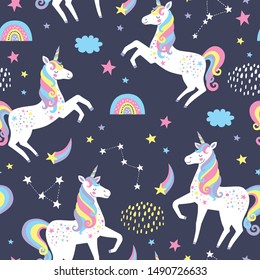 Hand drawn seamless vector pattern with cute unicorns, stars and rainbow. Repetitive wallpaper on dark blue background. 