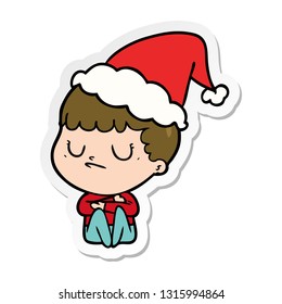 hand drawn sticker cartoon of a grumpy boy wearing santa hat
