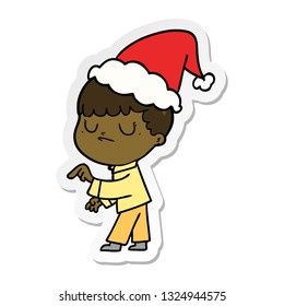 hand drawn sticker cartoon of a grumpy boy wearing santa hat